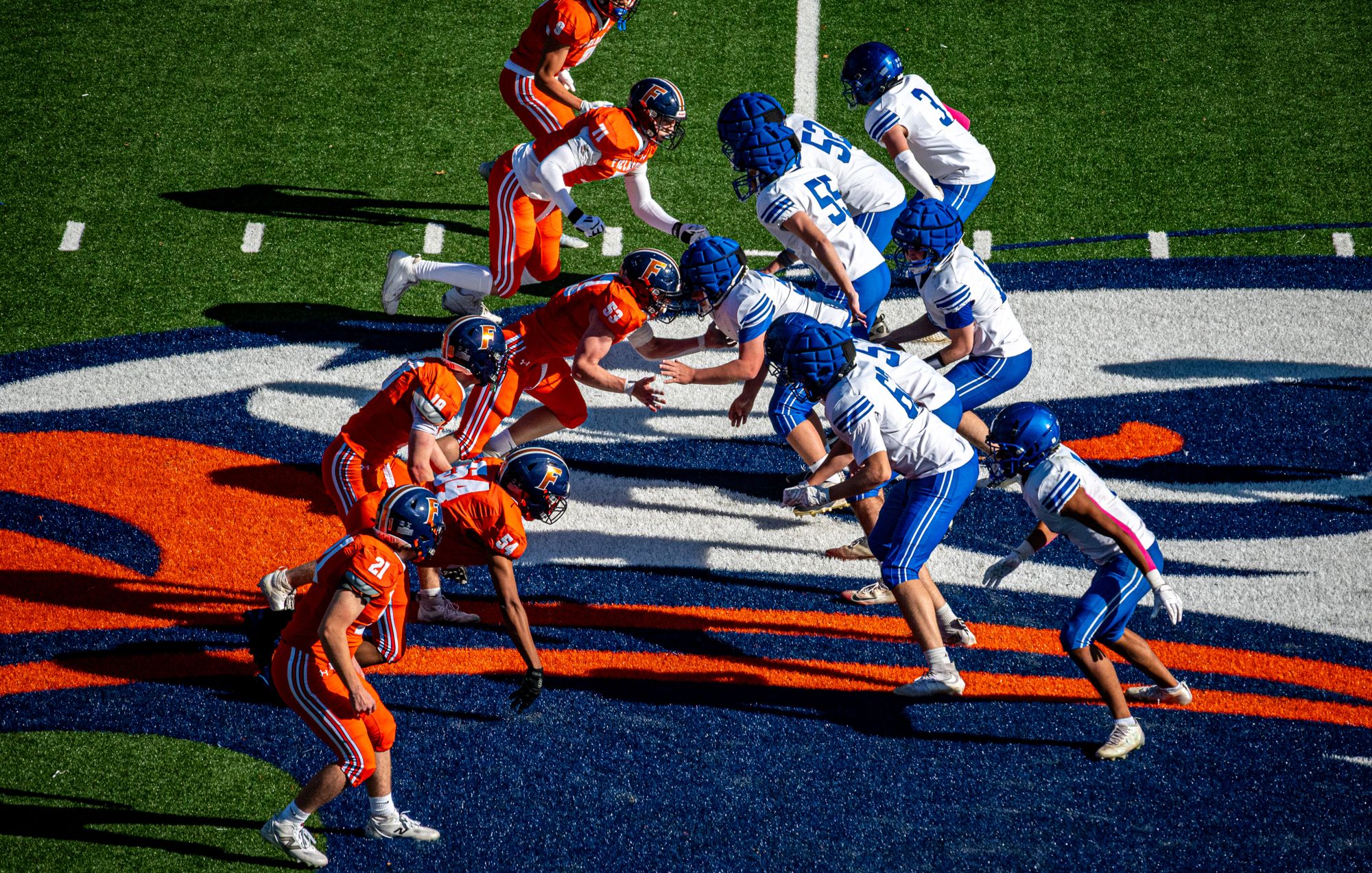 Fieldston and Dalton linemen face off over the painted eagle logo at midfield